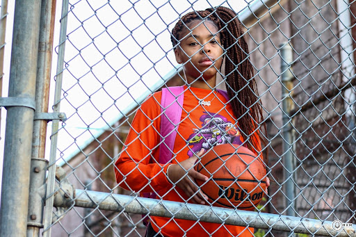 College student holds basketball.