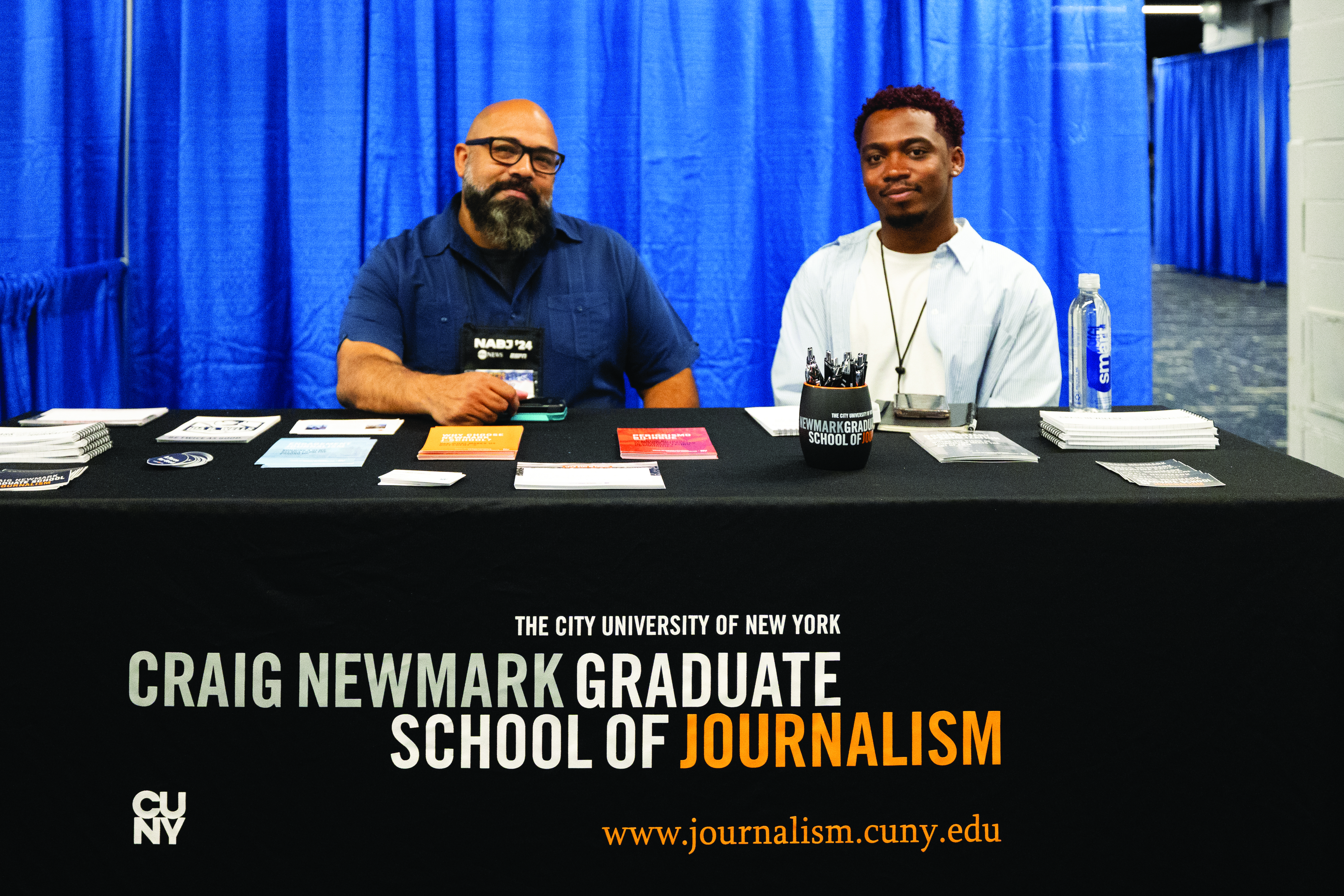 Maximo Patino and Divine Williams from the Craig Newmark Graduates School of Journalism greet NABJ members at their booth at the NABJ 2024 Convention & Career Fair at the Hilton Chicago on Thursday August 1, 2024. Armani Ross/NABJ Monitor