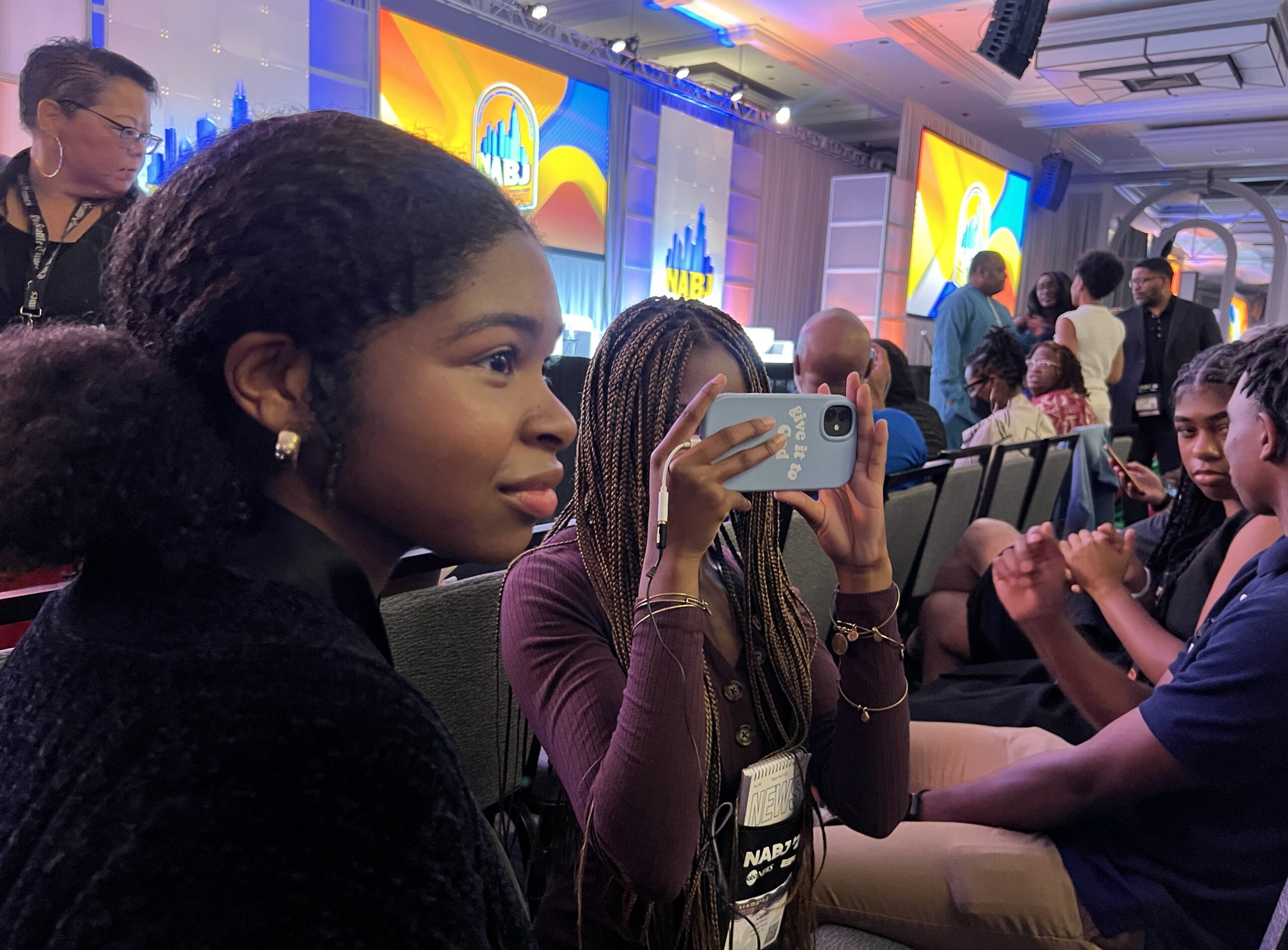JSHOP students Ryann Dawson (left) and Jada Strong (holding phone) conduct interviews before former President Donald Trump speaks at the NABJ convention in Chicago. JSHOP Staff